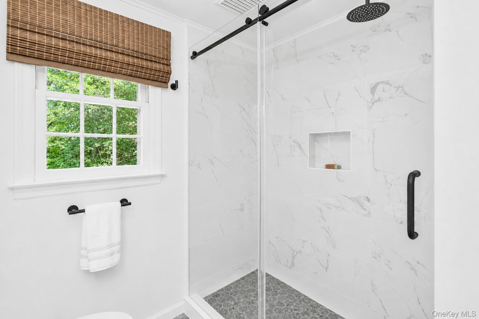 275 Pinewood Road Cutchogue, NY 11935 - Photo 31 of 45 Glass-enclosed shower with a rainfall showerhead, tiled walls, and a built-in shower niche