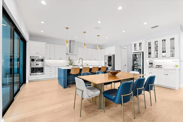 a kitchen with granite countertop a table chairs stove and cabinets