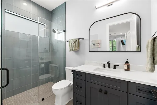 a spacious bathroom with a sink double vanity granite tub shower and mirror