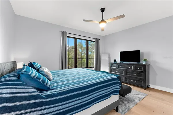 a view of swimming pool with lounge chair and trees in the background