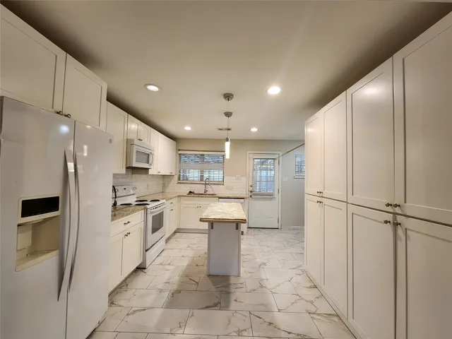 a kitchen with stainless steel appliances a refrigerator sink and cabinets