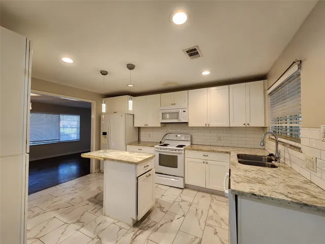 a kitchen with a sink stove and cabinets