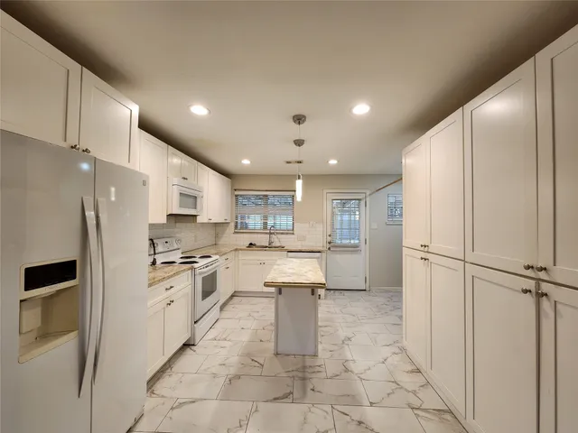a kitchen with stainless steel appliances a refrigerator sink and cabinets
