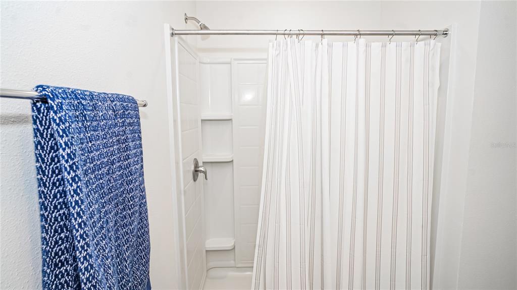 13253 Mylion Way Spring Hill, FL 34610 - Photo 23 of 31 a bathroom with a shower curtain and a window