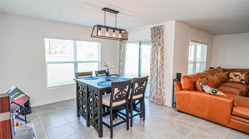 13253 Mylion Way Spring Hill, FL 34610 - Photo 8 of 31 a living room with furniture a window and a chandelier