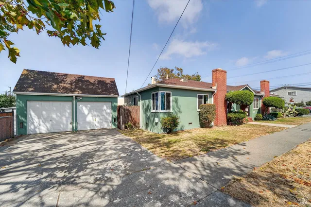 a front view of a house with a yard and potted plants
