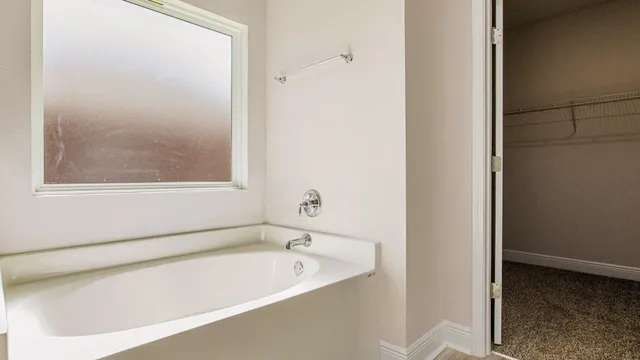 a bathroom with a bathtub and a window