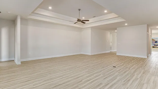 wooden floor in an empty room with a ceiling fan