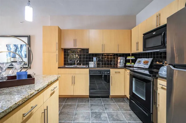 a kitchen with stainless steel appliances granite countertop a stove a sink and a microwave