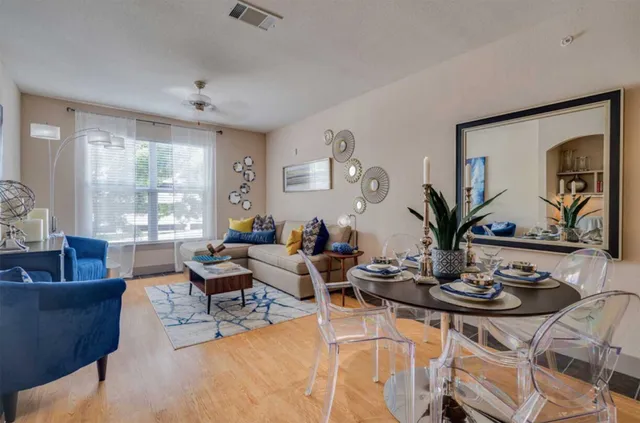 a living room with furniture kitchen view and large windows