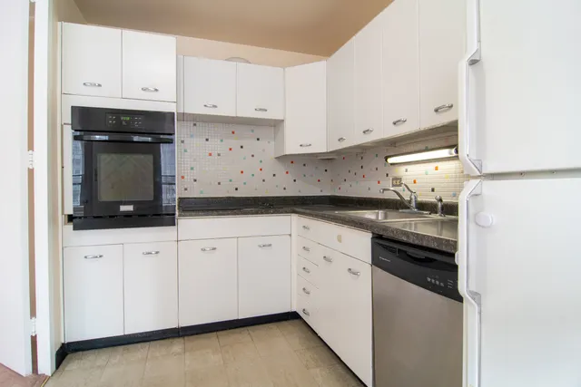 a kitchen with granite countertop white cabinets and black appliances