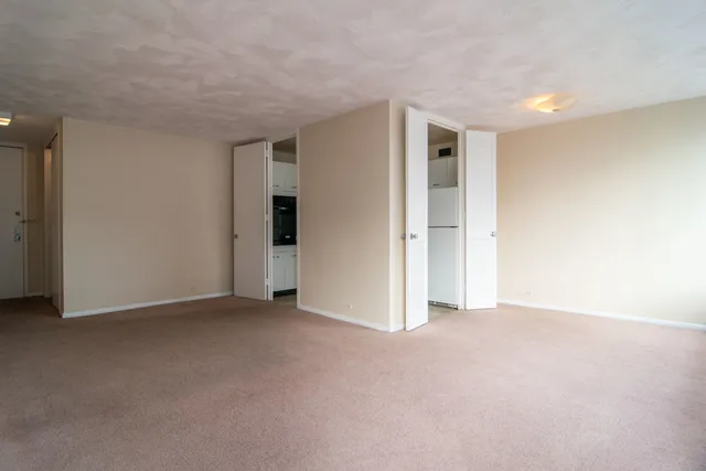 a view of an empty room with closet and a window