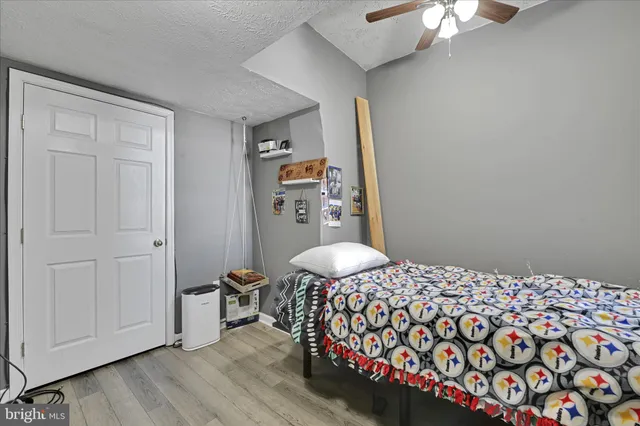 a bedroom with a bed and a lamp on dresser