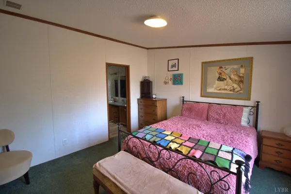 a bedroom with a bed and a dresser in it