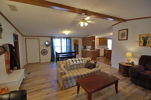 a living room with furniture a flat screen tv and kitchen view