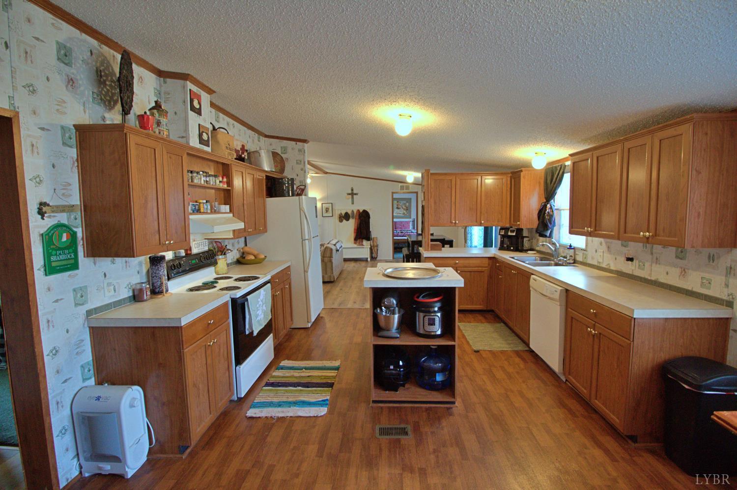 2112 Morning Star Road Appomattox, VA 24522 - Photo 8 of 24 a kitchen with stainless steel appliances kitchen island granite countertop a stove a sink and a refrigerator
