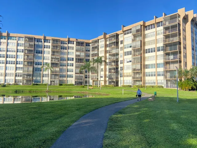 a view of a big building with a big yard and plants