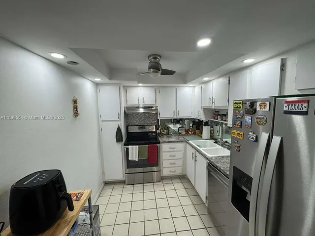 a kitchen with stainless steel appliances a refrigerator sink and microwave