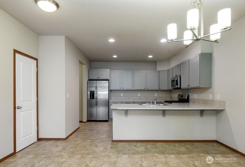 2425 Schley Boulevard Bremerton, WA 98310 - Photo 8 of 23 a kitchen with kitchen island a sink stainless steel appliances and cabinets