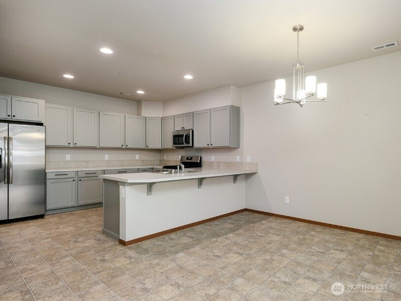 2425 Schley Boulevard Bremerton, WA 98310 - Photo 9 of 23 a kitchen with white cabinets and stainless steel appliances