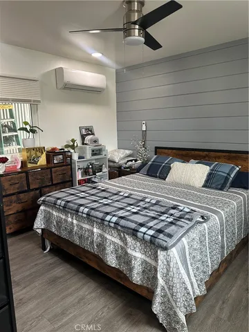 a bedroom with bed and wooden floor