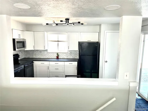 a kitchen with granite countertop a refrigerator and a stove