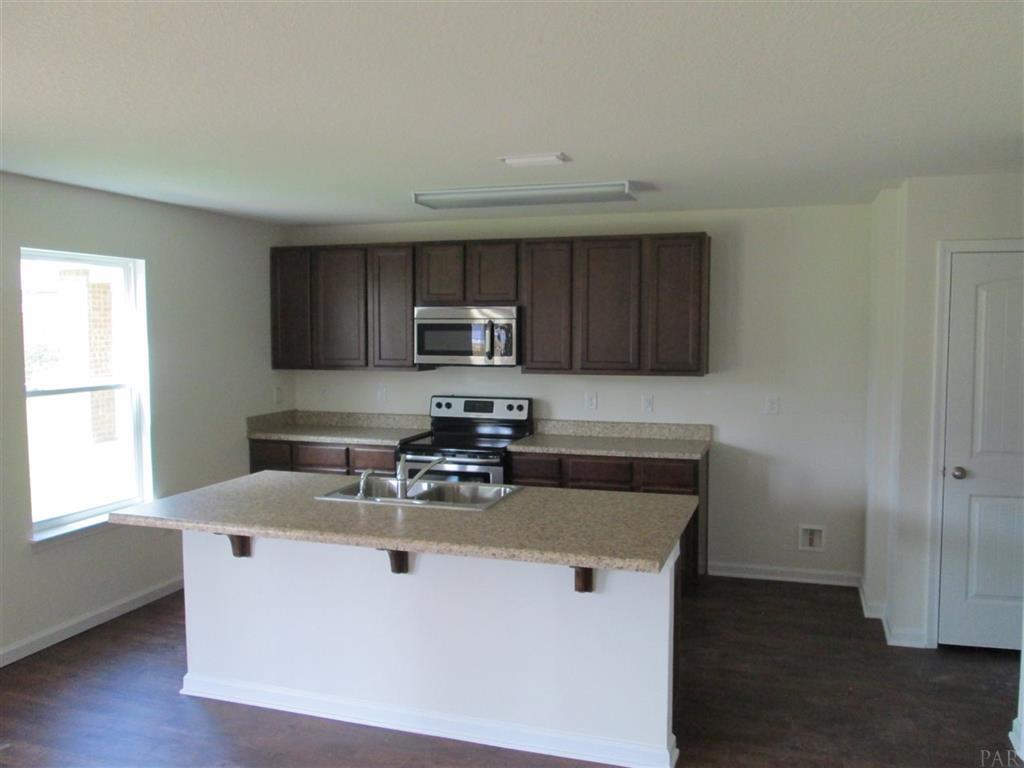 814 Moorhen Way Crestview, FL 32539 - Photo 4 of 8 a kitchen with kitchen island granite countertop a sink cabinets and stainless steel appliances