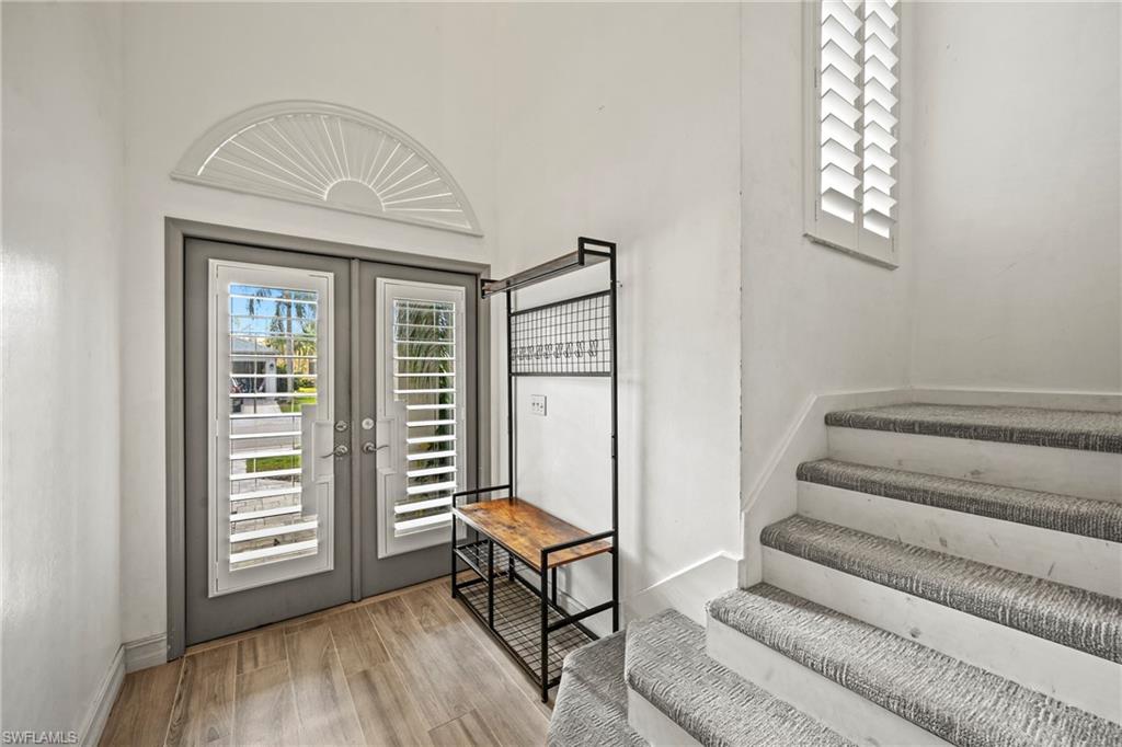 21684 Brixham Run Loop Estero, FL 33928 - Photo 13 of 26 Entryway with healthy amount of natural light, french doors, light wood finished floors, and stairs