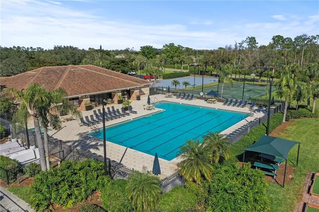 a view of a swimming pool with lawn chairs under an umbrella
