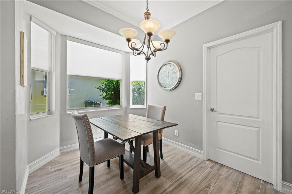 21684 Brixham Run Loop Estero, FL 33928 - Photo 7 of 26 Dining space with light wood-style floors, a chandelier, and crown molding