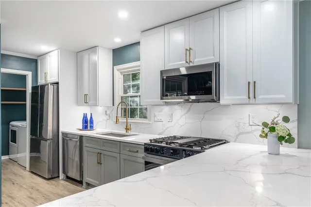 a kitchen with stainless steel appliances a stove a sink and a microwave