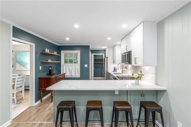 a kitchen with granite countertop a table chairs sink and cabinets