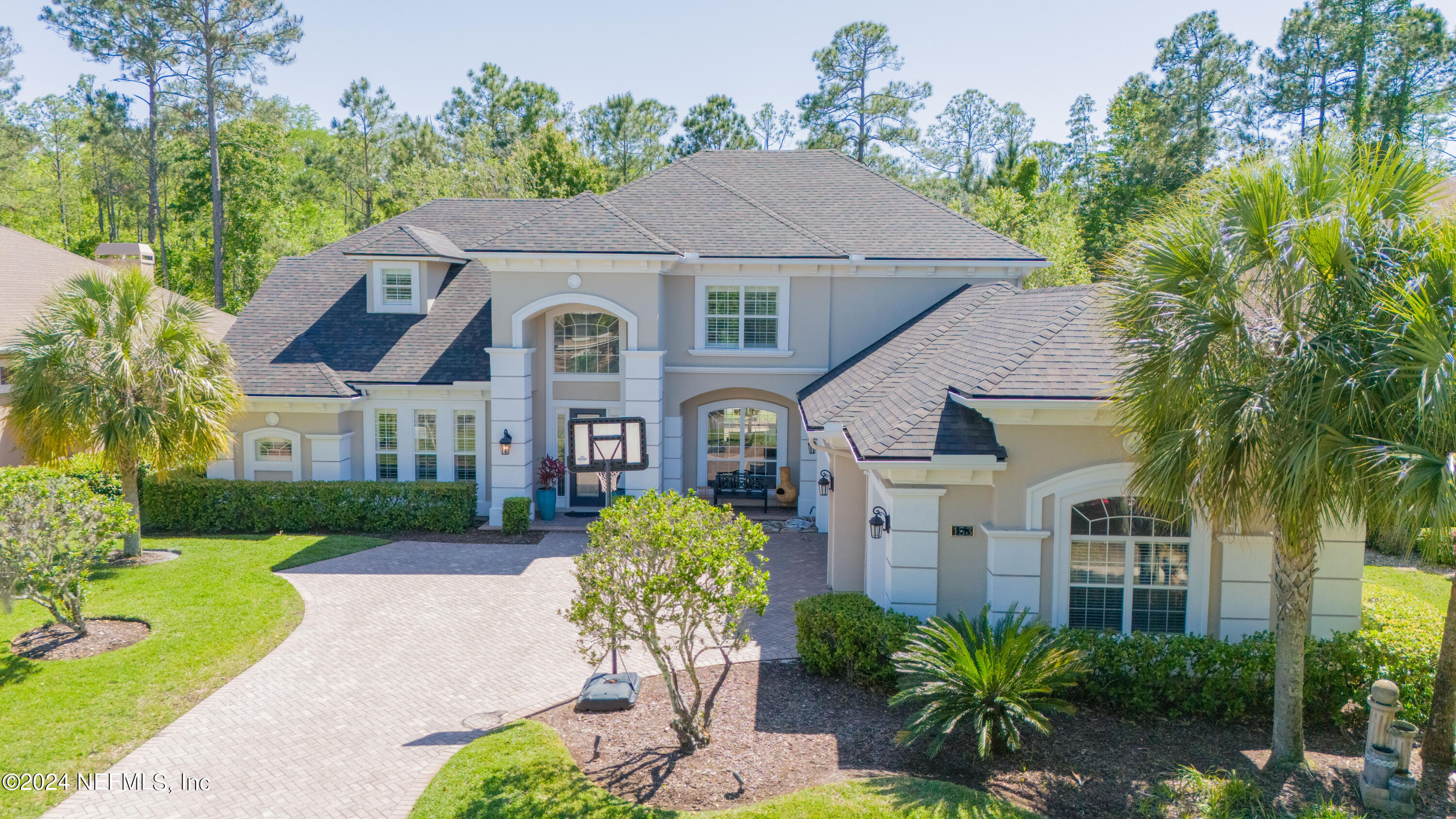a front view of a house with a yard garden and outdoor seating