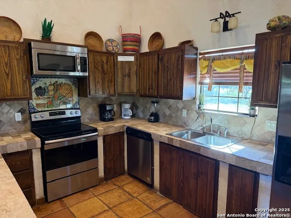 a kitchen with granite countertop a stove and cabinets
