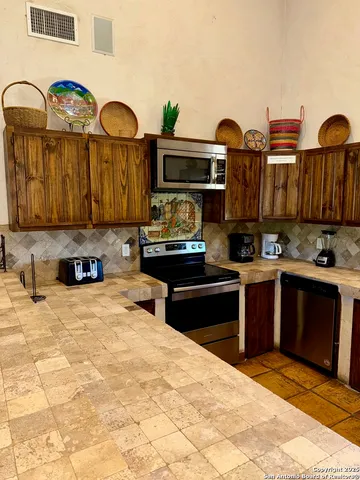 a kitchen with stainless steel appliances kitchen island granite countertop a refrigerator and stove