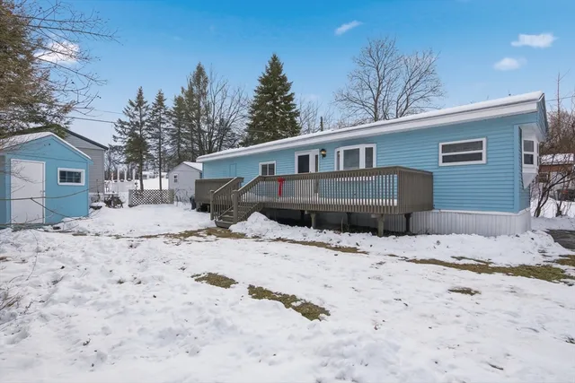 a front view of a house with a yard covered in snow