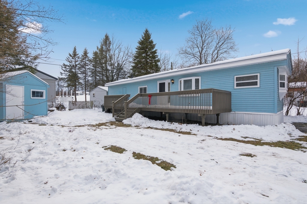 18 Maple Street, Unit 14 Pepperell, MA 01463 - Photo 1 of 27 a front view of a house with a yard covered in snow