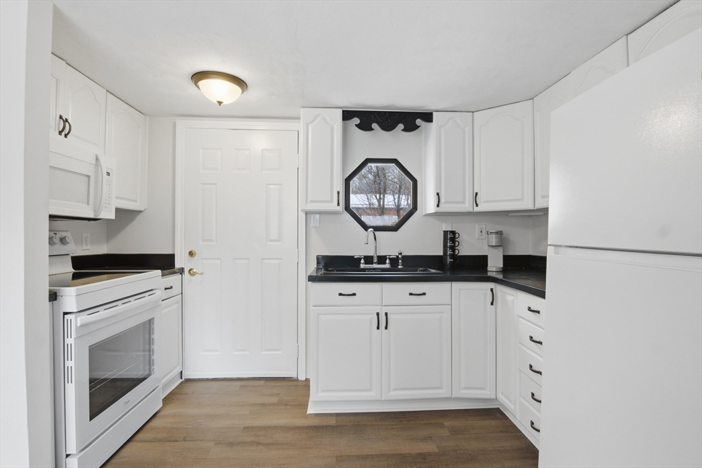 18 Maple Street, Unit 14 Pepperell, MA 01463 - Photo 11 of 27 a kitchen with white cabinets and white appliances