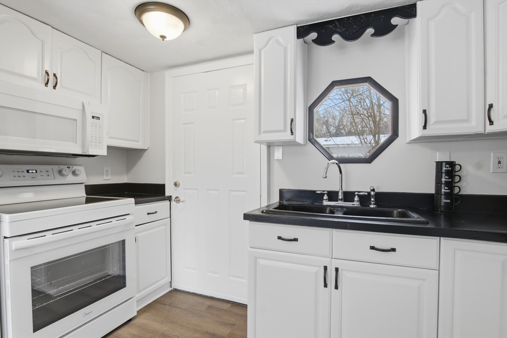 18 Maple Street, Unit 14 Pepperell, MA 01463 - Photo 12 of 27 a kitchen with granite countertop a sink cabinets and stainless steel appliances