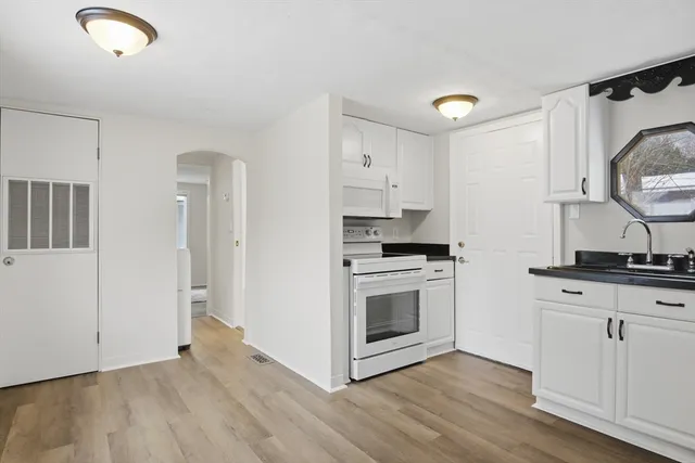 a kitchen with granite countertop a sink cabinets and stainless steel appliances