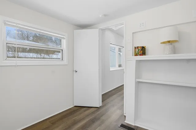 a view of kitchen with wooden floor and cabinets