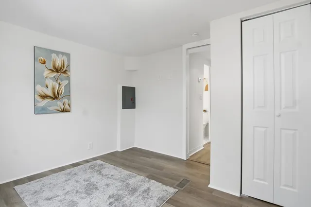 a view of a hallway with wooden floor and closet