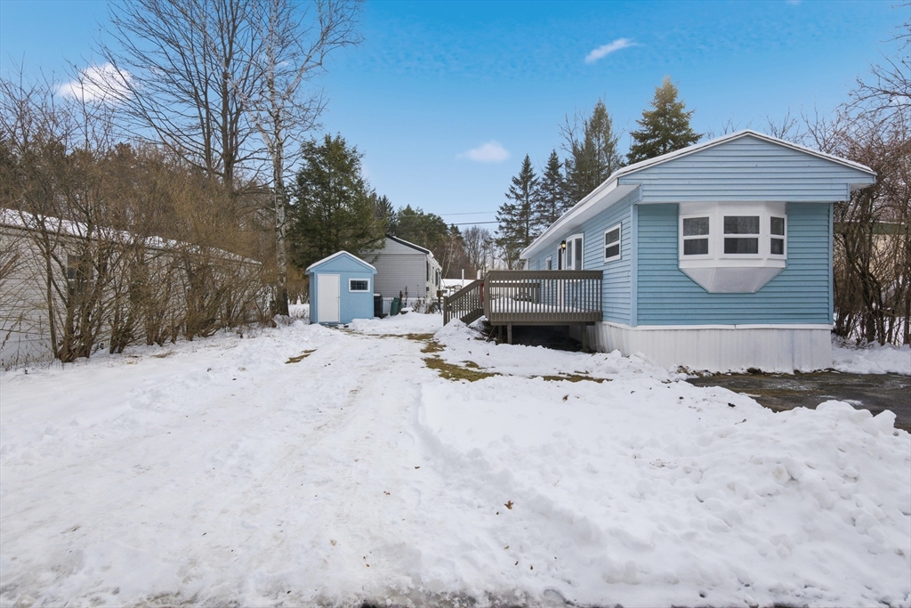18 Maple Street, Unit 14 Pepperell, MA 01463 - Photo 2 of 27 a front view of a house with a yard covered in snow