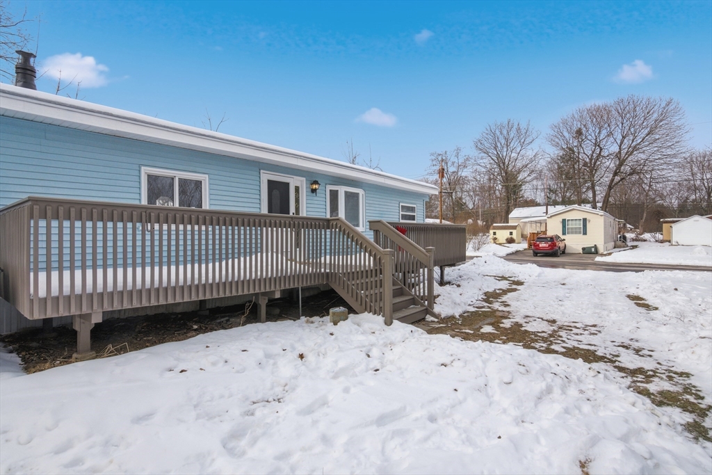 18 Maple Street, Unit 14 Pepperell, MA 01463 - Photo 26 of 27 a view of a house with a yard covered in snow