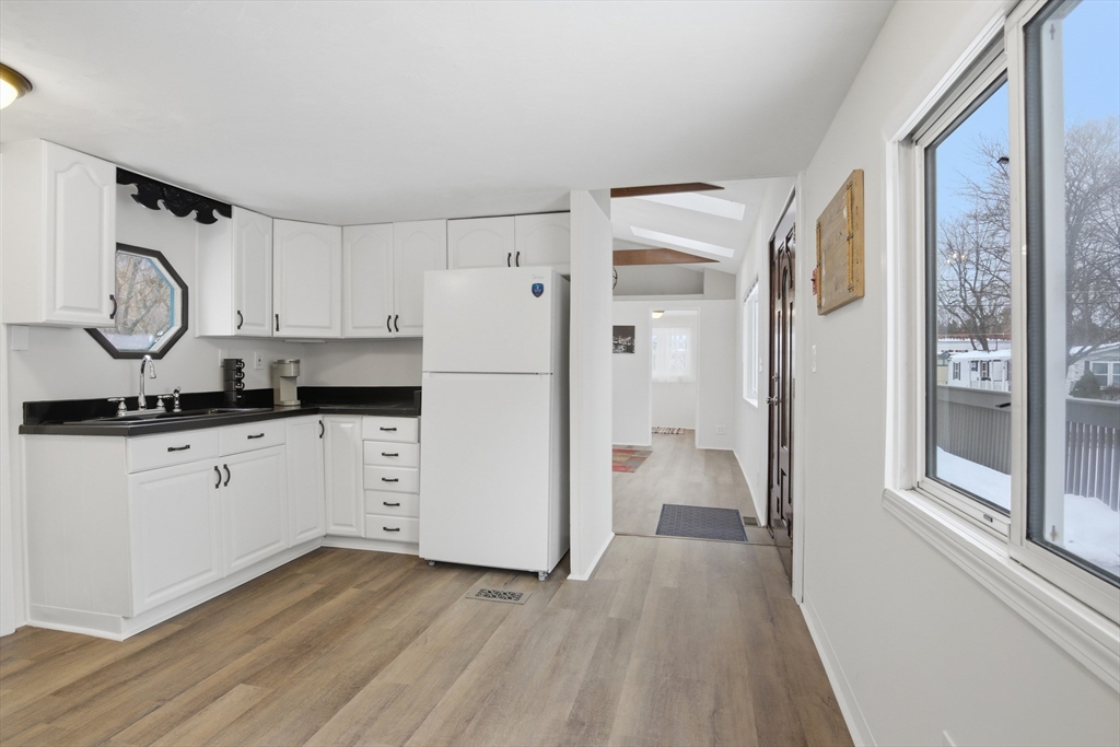 18 Maple Street, Unit 14 Pepperell, MA 01463 - Photo 9 of 27 a kitchen with a refrigerator and white cabinets