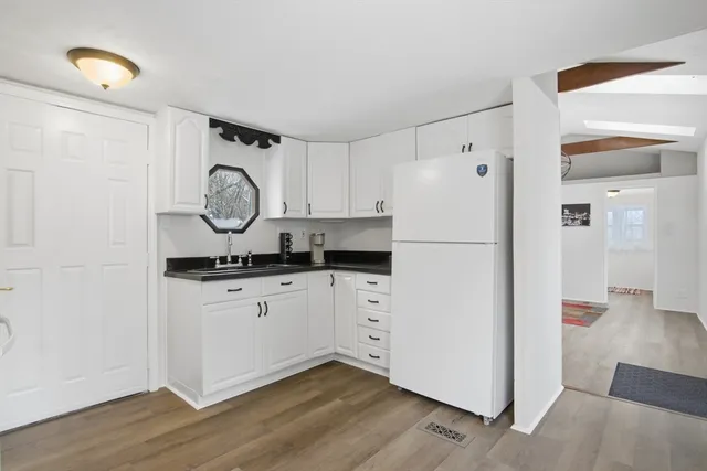 a white kitchen with a refrigerator and a stove