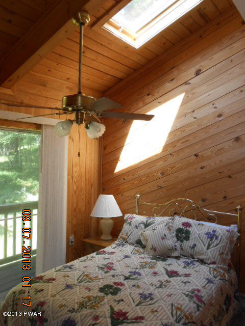 144 Raccoon Court Bushkill, PA 18324 - Photo 16 of 29 a bedroom with a bed and a chandelier