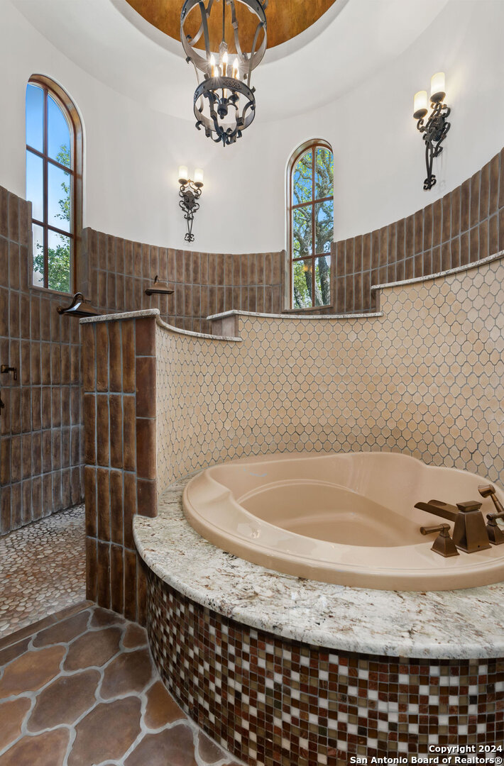 211 Augusta Boerne, TX 78006 - Photo 40 of 59 a bathroom with a granite countertop sink a mirror and bathtub