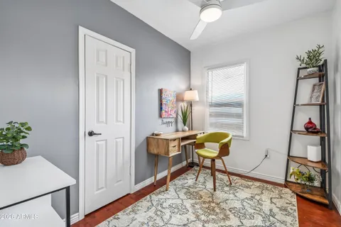 a view of a workspace with furniture and a window