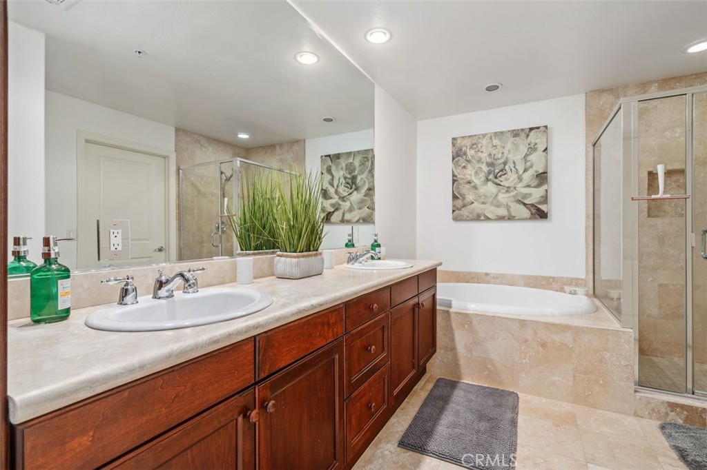 128 North Oak Knoll Avenue, Unit 317 Pasadena, CA 91101 - Photo 15 of 22 a bathroom with a double vanity sink large mirror and a bathtub